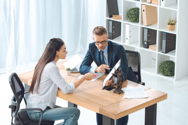 Lawyer Consulting with Client in Modern Office – Local SEO for Law Firms Professional meeting between a lawyer and client discussing documents in a modern office with legal files and decor in the background.