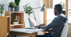 a man working from a laptop from what appears to be an at-home desk