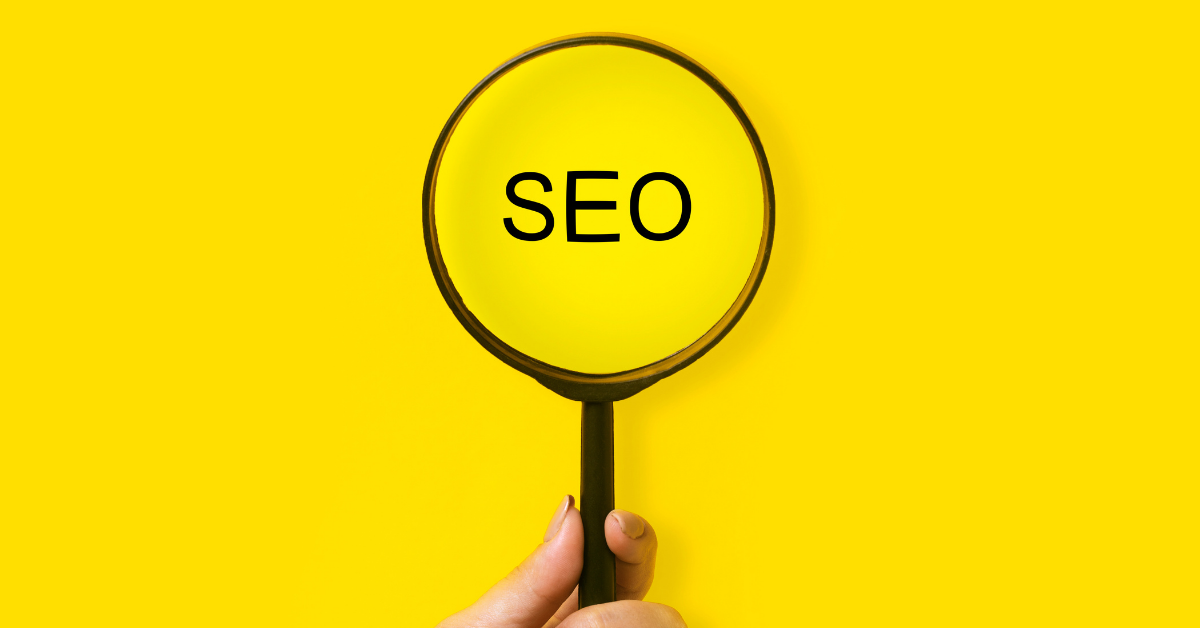 A magnifying glass over the word SEO on a yellow background