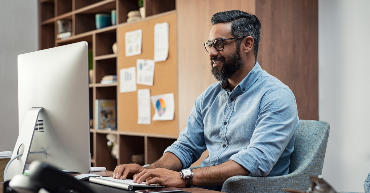 A man working on a computer in an office setting.