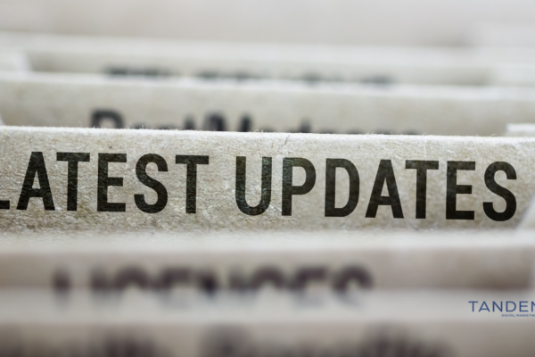 Digital Marketing March Updates – Tandem Interactive Close-up of file folder labeled "Latest Updates" with Tandem Digital Marketing logo in the corner.