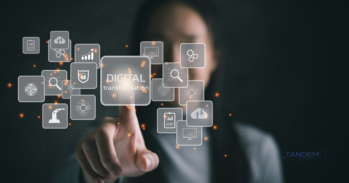 Person interacting with a digital interface featuring icons for analytics, cloud storage, automation, and the phrase "Digital Transformation"; Tandem Digital Marketing logo in the corner.