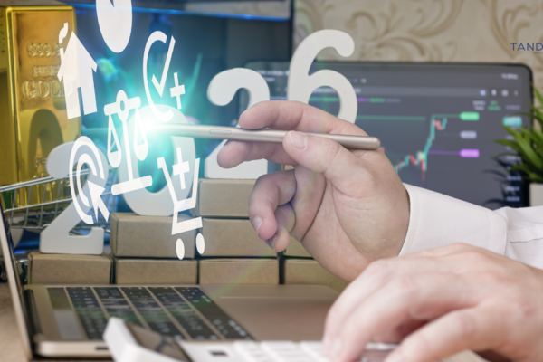 A professional strategist using a stylus to analyze 2026 digital marketing growth trends on a laptop, featuring the Tandem Interactive logo, holographic data icons, and symbols of high-value ROI and financial success.