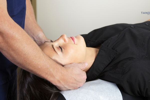 A chiropractor performing a neck adjustment on a patient, representing Tandem Interactive's specialized local SEO and digital marketing services for chiropractic practices.
