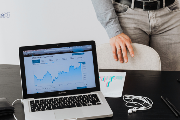 A clean, professional workspace showing a MacBook Pro displaying a market growth chart and data trends, representing Tandem Interactive’s February 2026 digital marketing updates and strategic performance reviews.